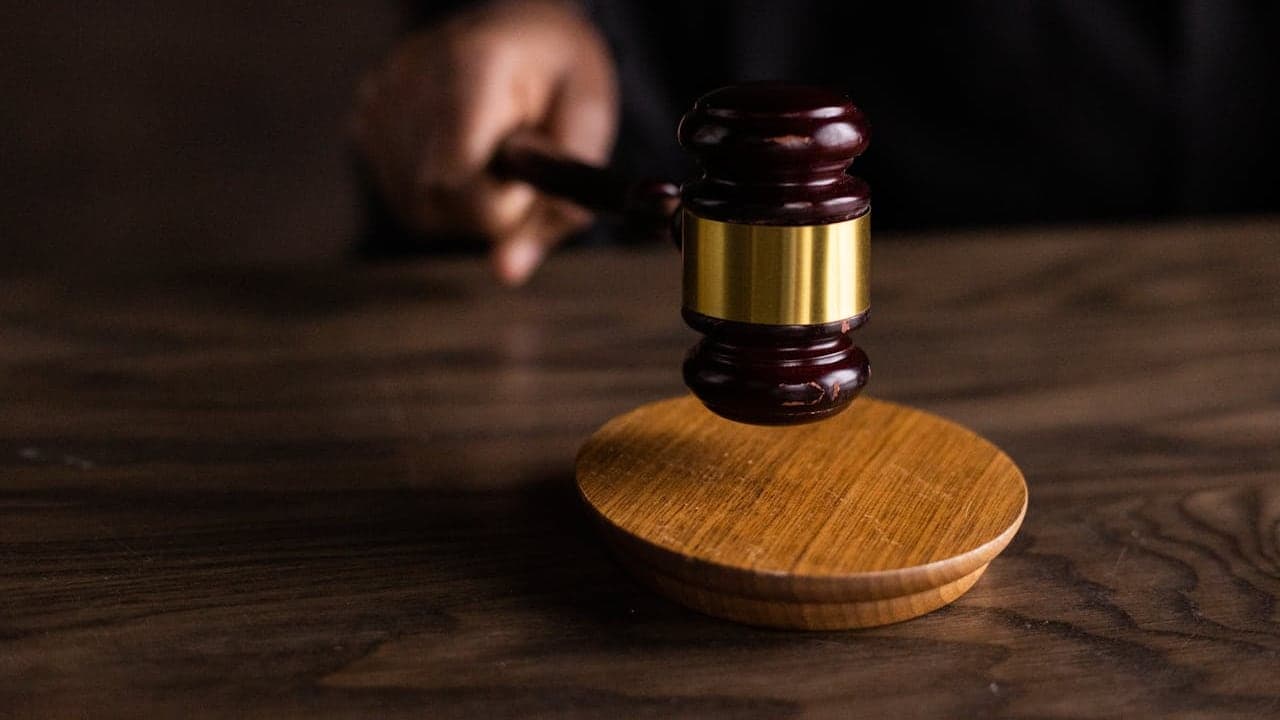 Un mazo de juez sobre su soporte, que evoca una ley y su aplicación