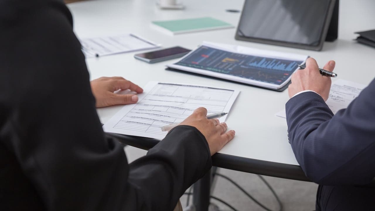 Dos profesionales revisando una propuesta de proveedor sobre una mesa