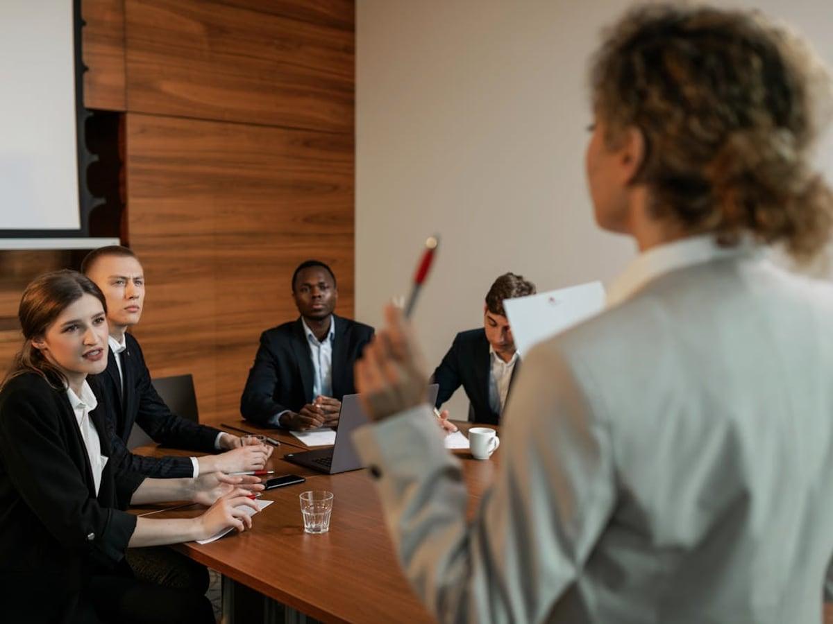 Una profesional exponiendo conclusiones ante un comité en una sala de juntas